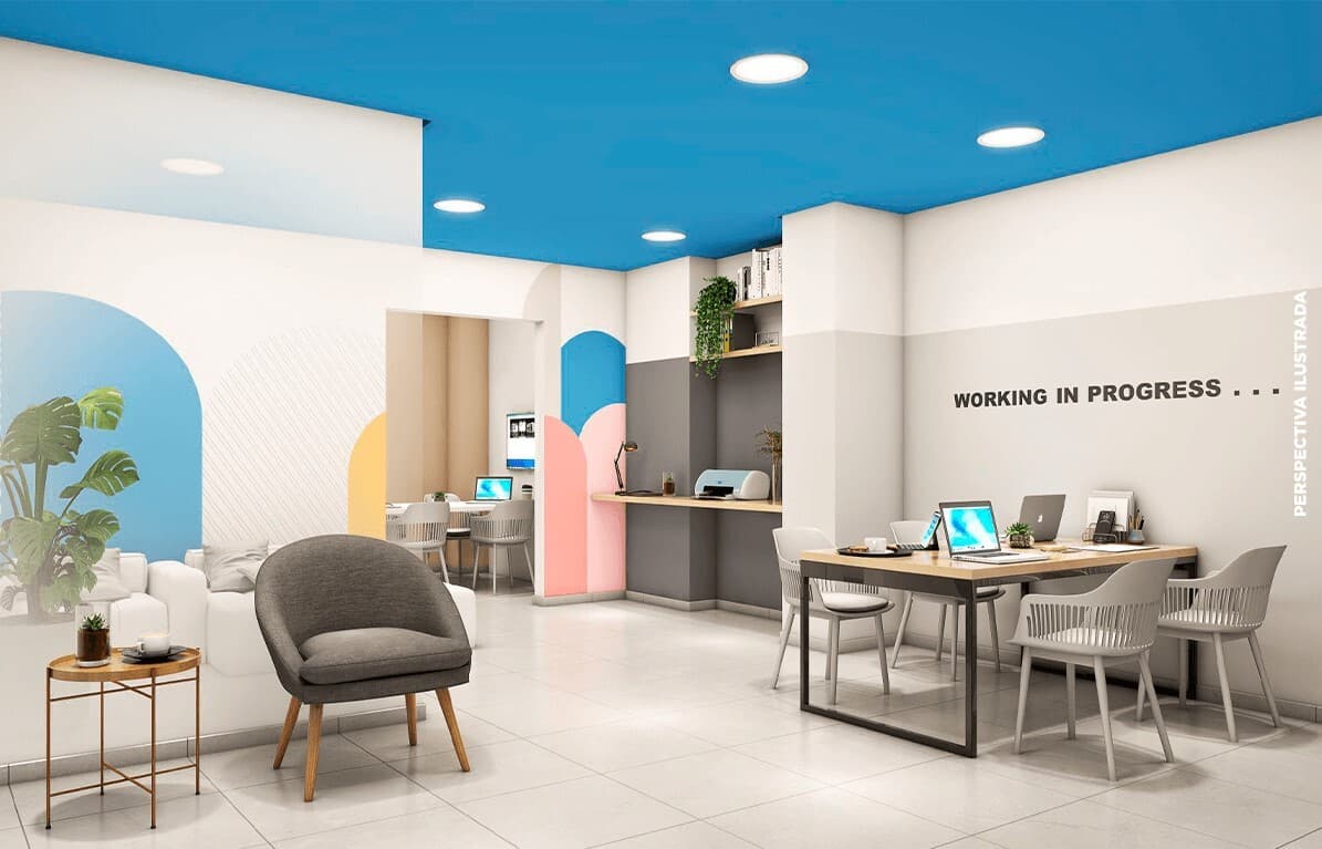 Espaco de coworking com mesas de estudo, computadores e poltronas