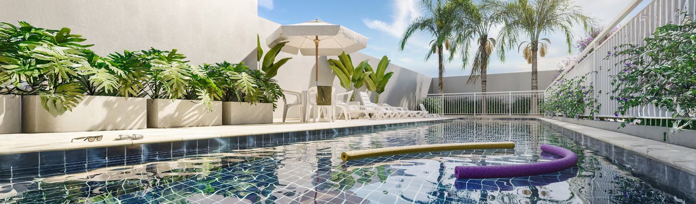 Piscina ao ar livre com espreguiçadeiras, guarda-sol e vasos de plantas ao redor