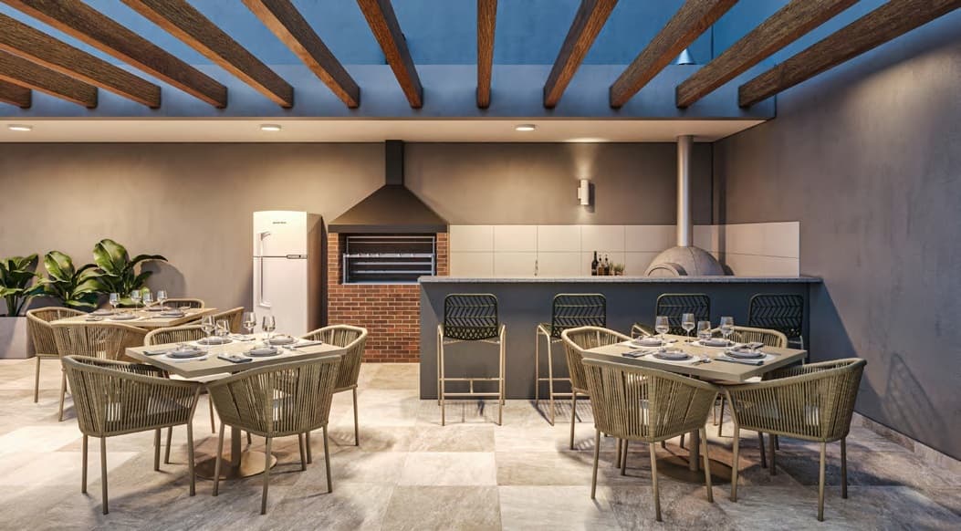 Área gourmet externa com churrasqueira, forno de pizza e mesas com cadeiras.